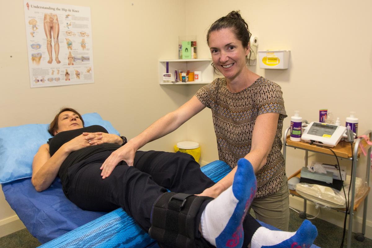 Physiotherapist working on patients leg