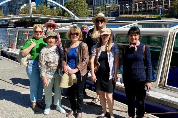 Group of people standing beside a cruise boat on Yarra River